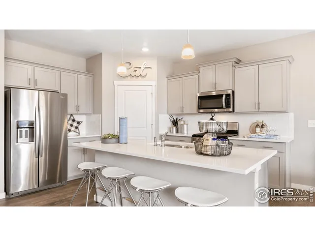 a kitchen with refrigerator a sink and chairs