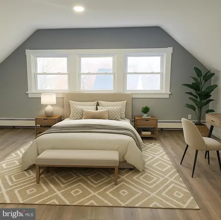 a bedroom with a bed a table and chair with the potted plant