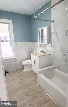 a bathroom with a sink toilet vanity and bathtub