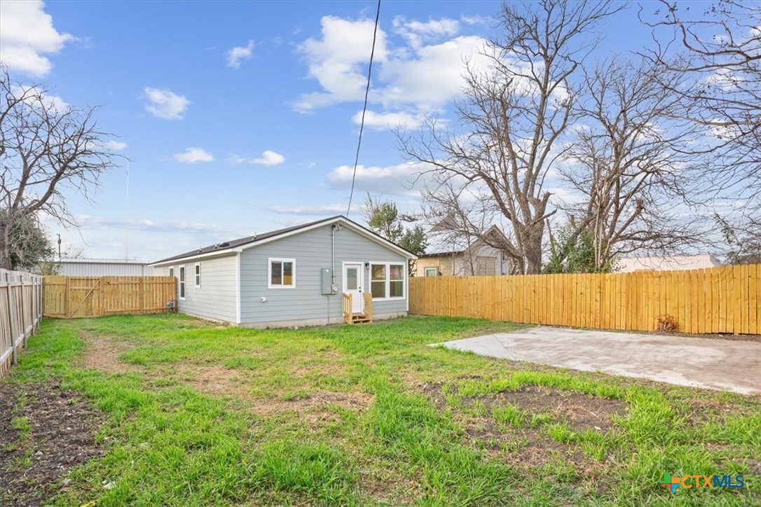 707 South 13th Street Temple, TX 76504 - Photo 23 of 24 a house that is sitting in the grass with large trees and plants