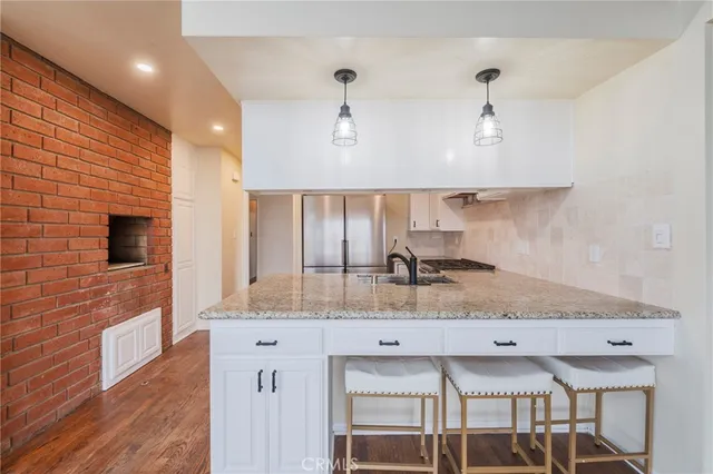 a kitchen with stainless steel appliances granite countertop a sink a stove counter space and cabinets