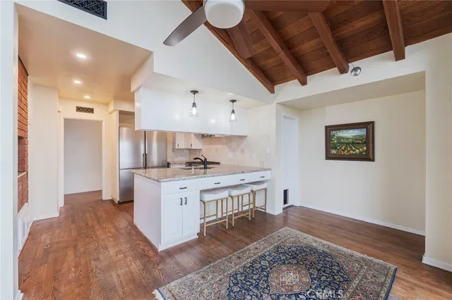 a large kitchen with a lot of counter space and wooden floor