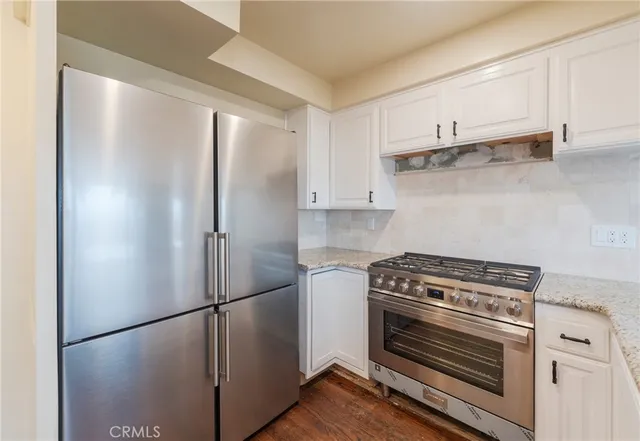 a kitchen with refrigerator a stove and cabinets