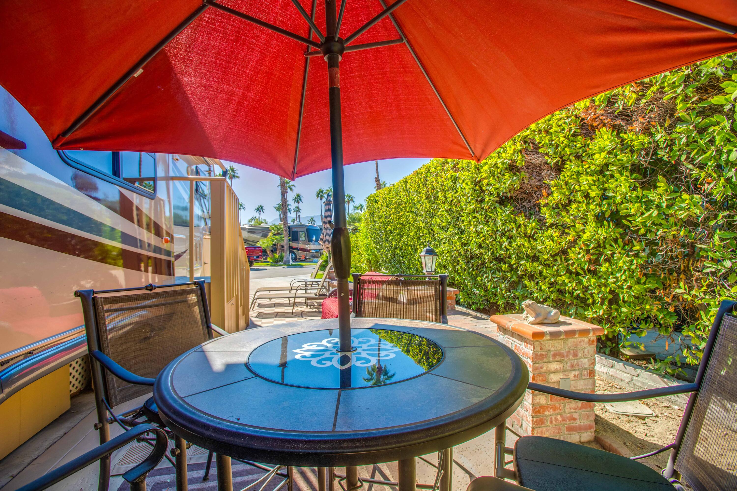 69411 Ramon Road, Unit 360 Cathedral City, CA 92234 - Photo 29 of 66 a patio with a table and chairs under an umbrella