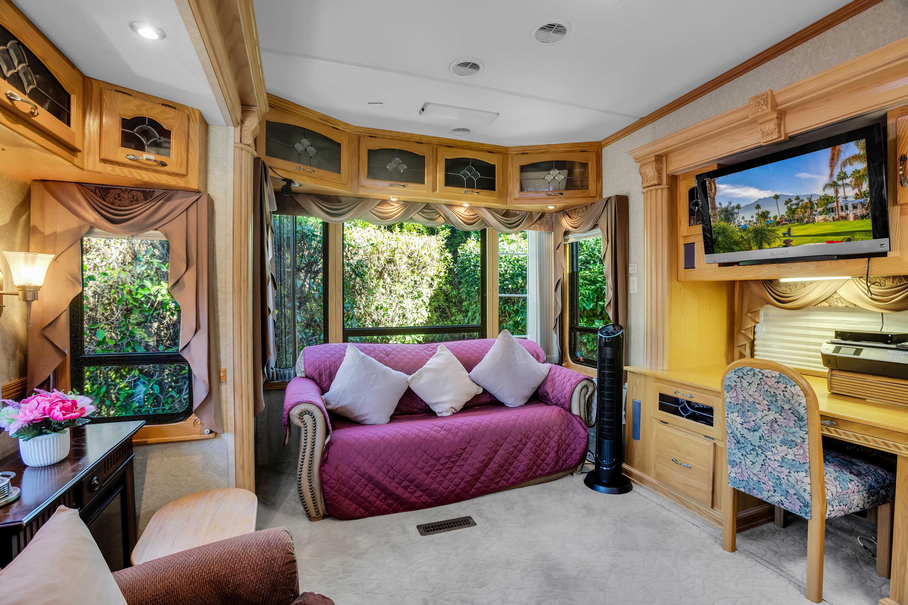 69411 Ramon Road, Unit 360 Cathedral City, CA 92234 - Photo 3 of 66 a living room with furniture a flat screen tv and a floor to ceiling window