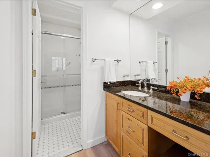 a bathroom with a shower sink and mirror
