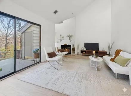 a living room with furniture a fireplace and a floor to ceiling window
