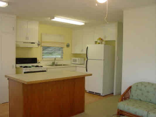 44 Kilua Road Hilo, HI 96720 - Photo 5 of 15 a kitchen with stainless steel appliances granite countertop a refrigerator a stove a sink and white cabinets