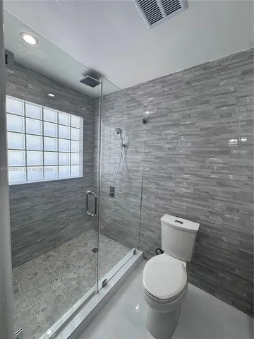 a bathroom with a toilet and a shower