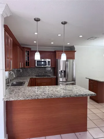 a large kitchen with kitchen island a sink stainless steel appliances and a counter top space