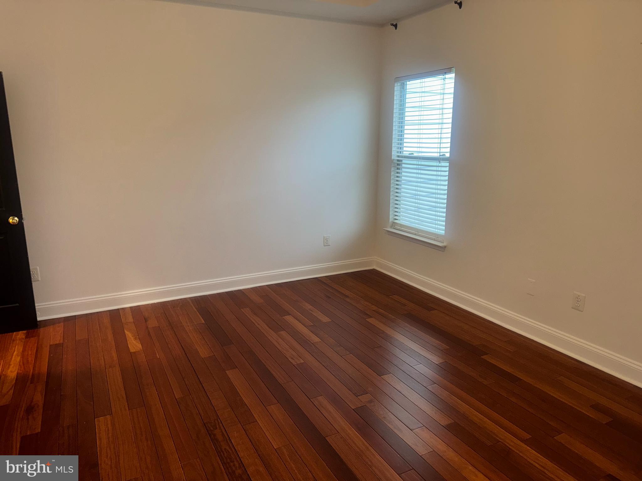 127 Albemarle Street, Unit 36 Baltimore, MD 21202 - Photo 17 of 25 a view of an empty room with wooden floor and a window