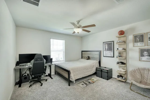 a living room with furniture and a ceiling fan