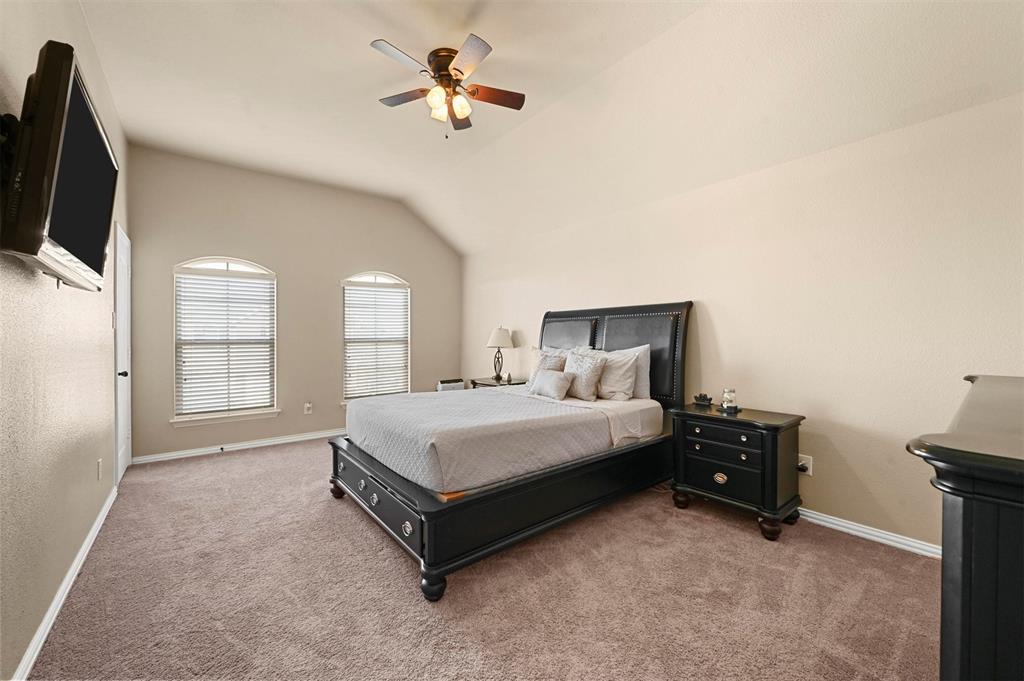 14815 Frisco Ranch Drive Little Elm, TX 75068 - Photo 26 of 40 a spacious bedroom with a bed and a tv on the dresser