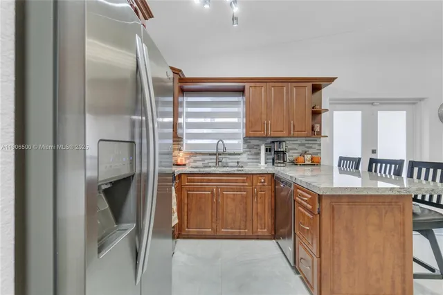 a kitchen with stainless steel appliances granite countertop a refrigerator and a stove top oven