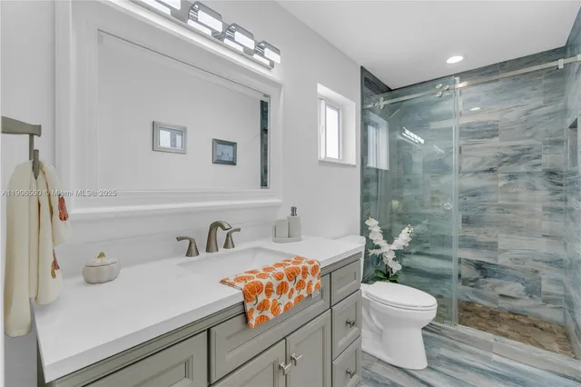 a bathroom with a sink a toilet and shower