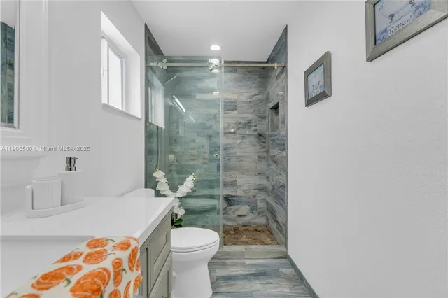 a bathroom with a shower a toilet and a sink