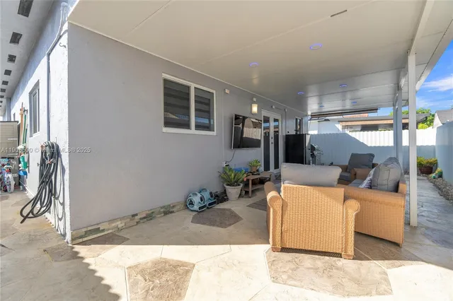 a living room with furniture a flat screen tv and a table