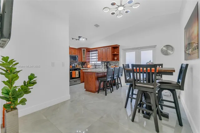 a dining room with furniture and a potted plant