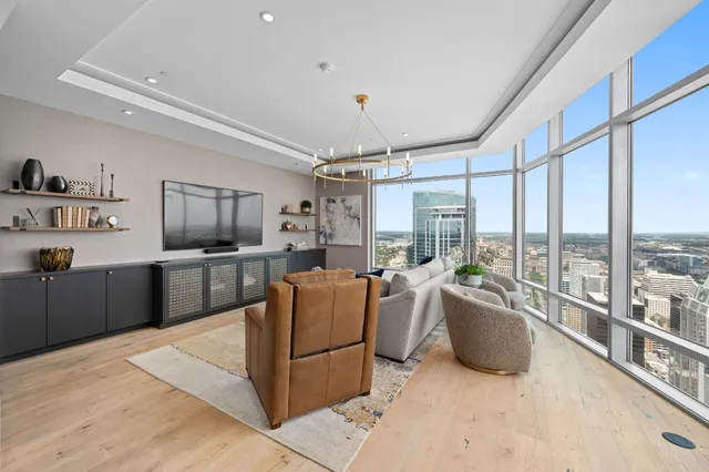 a living room with furniture large window and flat screen tv