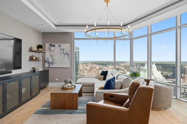 a very nice looking living room with a large window and a dining table