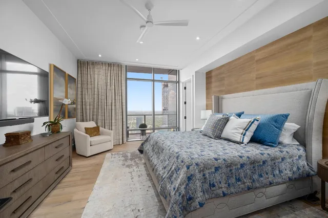 a bedroom with a large bed couch and windows