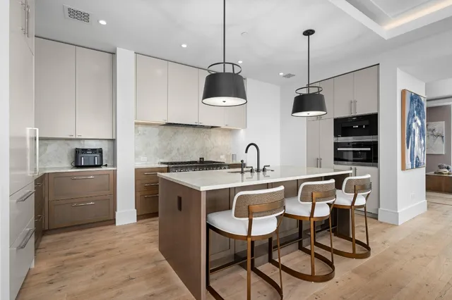 a kitchen with stainless steel appliances granite countertop a sink a stove a refrigerator and island