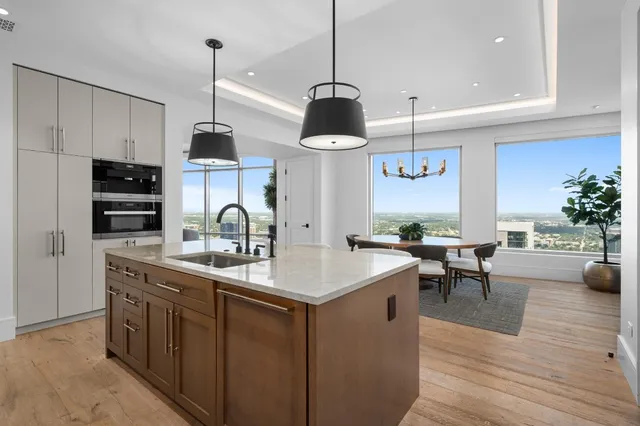 a kitchen with stainless steel appliances granite countertop a sink a stove and a wooden floors