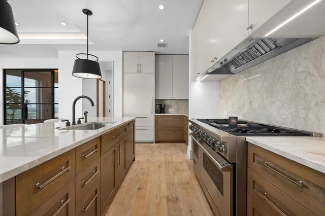 a kitchen with granite countertop a sink stove and cabinets