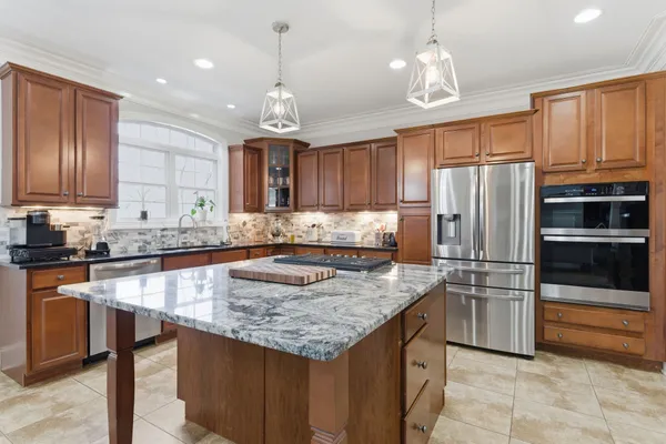 a kitchen with kitchen island granite countertop a stove oven and a view of living room