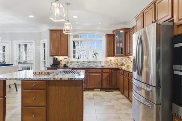 a kitchen with granite countertop cabinets stainless steel appliances a sink and a center island
