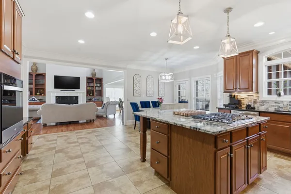 a kitchen with granite countertop a refrigerator and a stove top oven