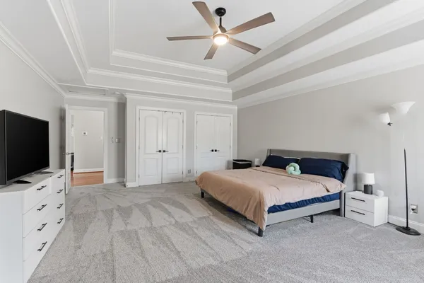 a bedroom with a bed a flat screen tv and a large window