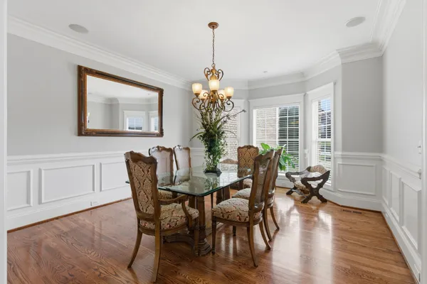 a dining room with furniture potted plants and wooden floor
