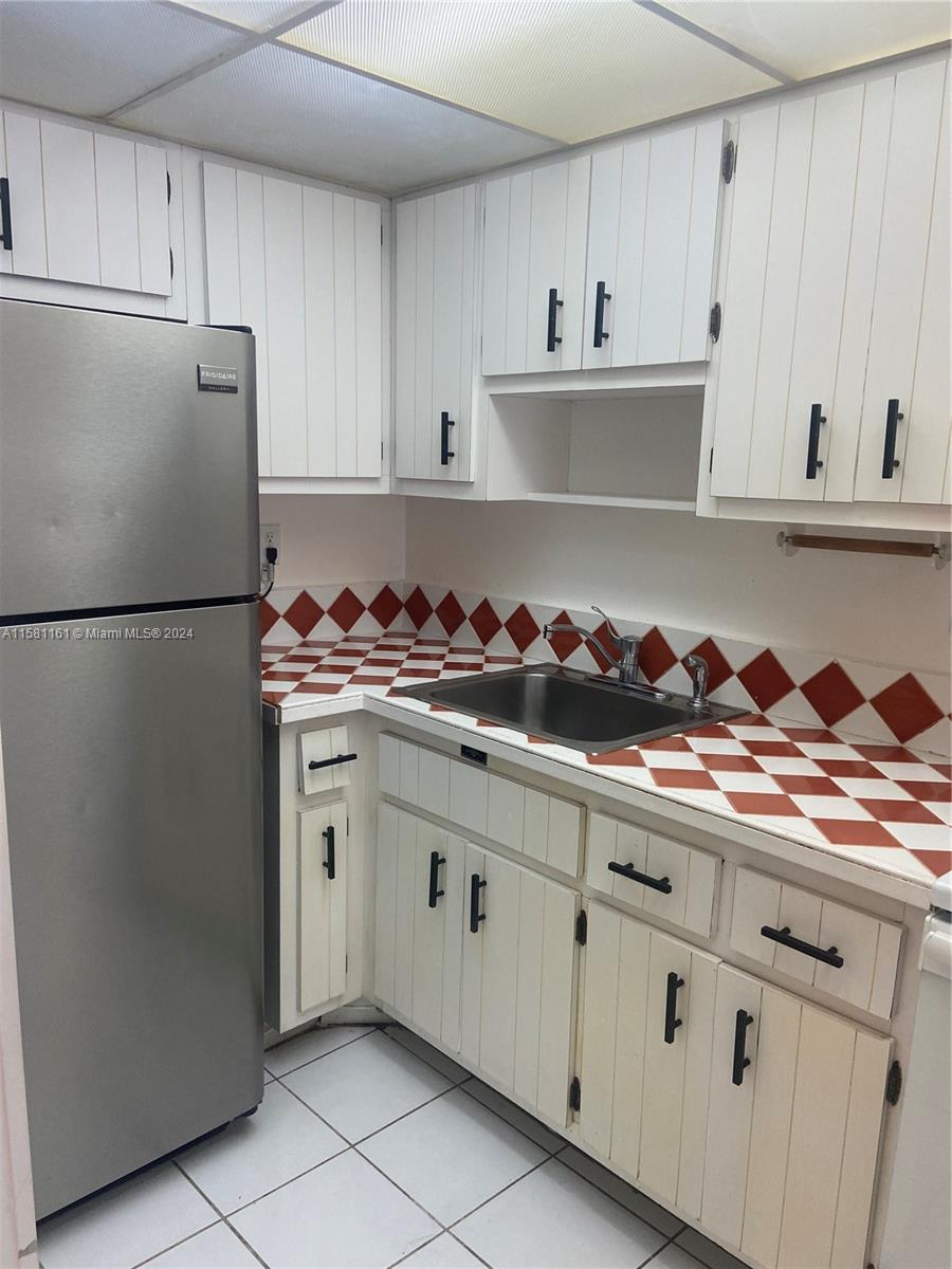 a kitchen with white cabinets and a stove with refrigerator
