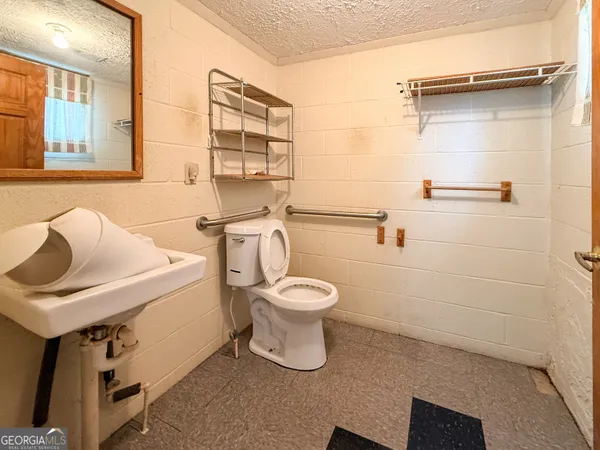 a bathroom with a toilet sink and mirror