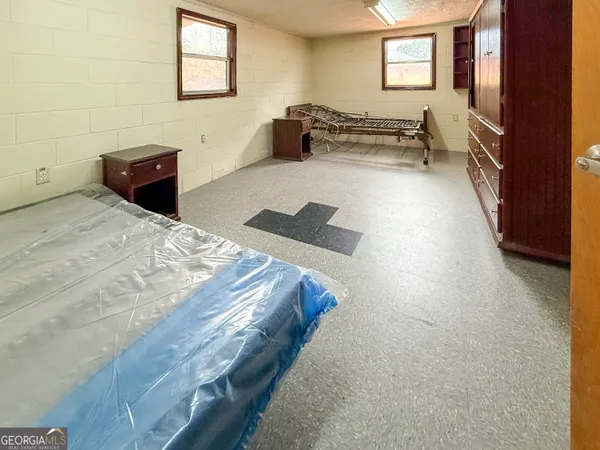 a spacious bedroom with a bed and a dresser