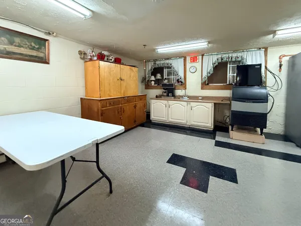 a kitchen with a table chairs microwave and cabinets