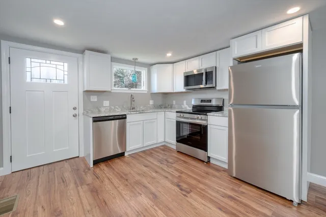 a kitchen with white cabinets and stainless steel appliances