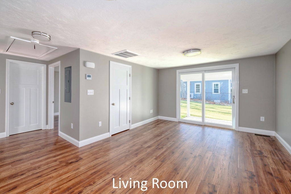665 State Road, Unit 2 Plymouth, MA 02360 - Photo 5 of 10 a view of an empty room with wooden floor and a window