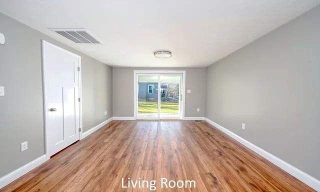 a view of room with window and wooden floor