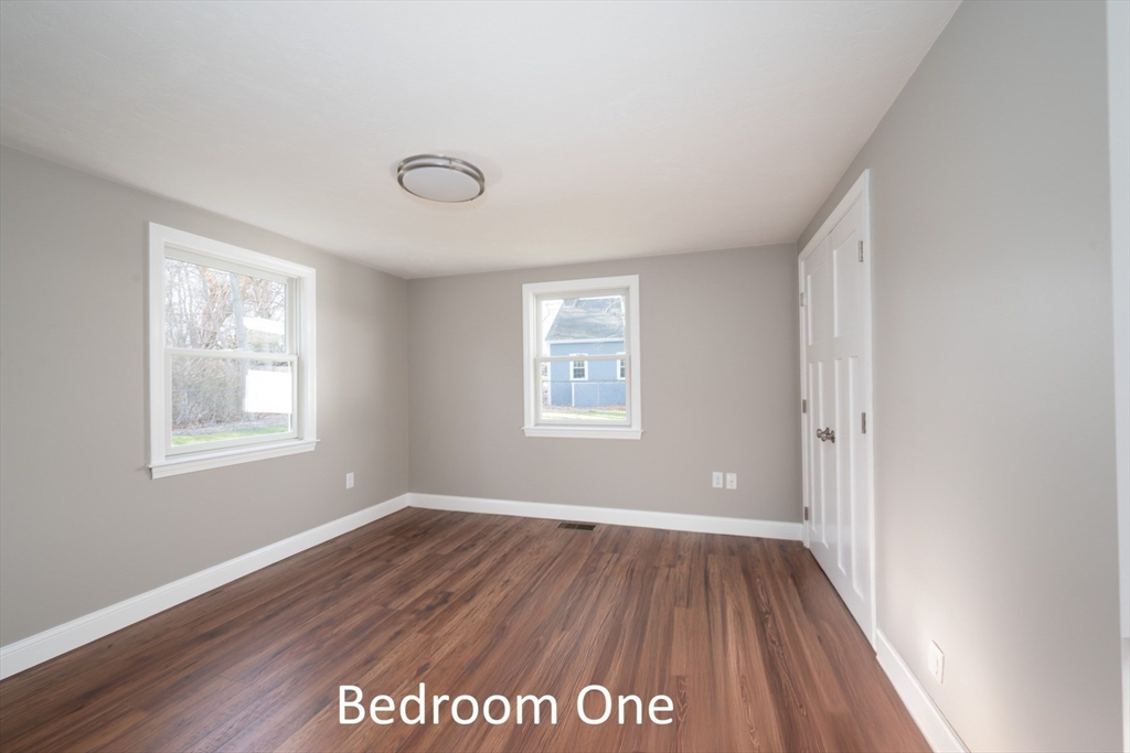 665 State Road, Unit 2 Plymouth, MA 02360 - Photo 9 of 10 a view of an empty room with wooden floor and a window