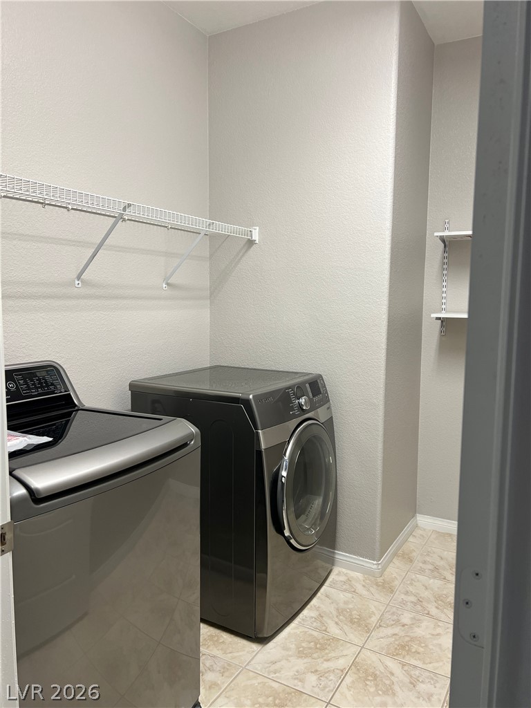 5981 Honeysuckle Ridge Street Las Vegas, NV 89148 - Photo 19 of 29 Functional laundry space featuring modern appliances and practical wall-mounted shelving for organized utility.