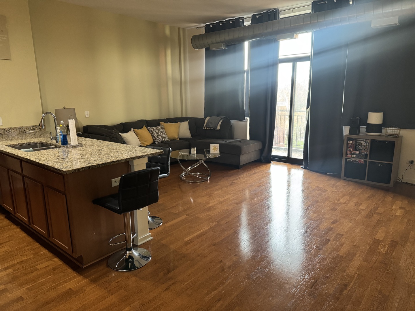 2323 West Pershing Road, Unit 417 Chicago, IL 60609 - Photo 2 of 8 a open kitchen with a sink dishwasher a stove and a dining table with wooden floor