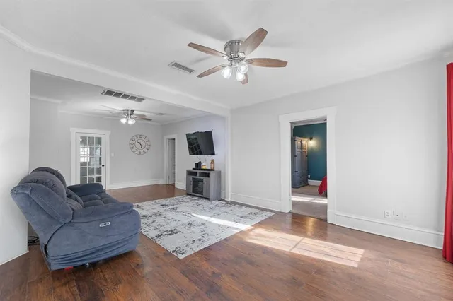 a living room with furniture and a wooden floor