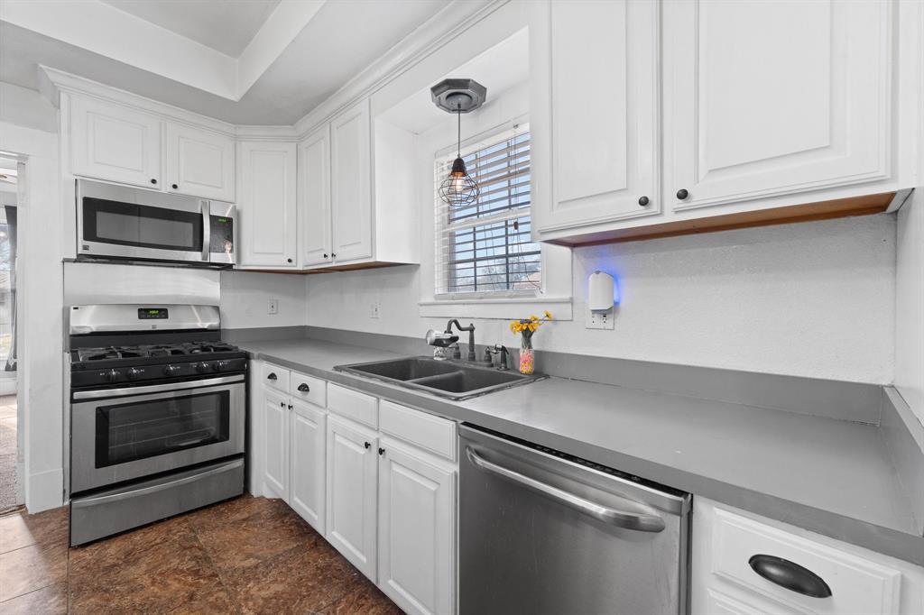 700 Euclid Street Cleburne, TX 76033 - Photo 10 of 35 a kitchen with granite countertop white cabinets and stainless steel appliances