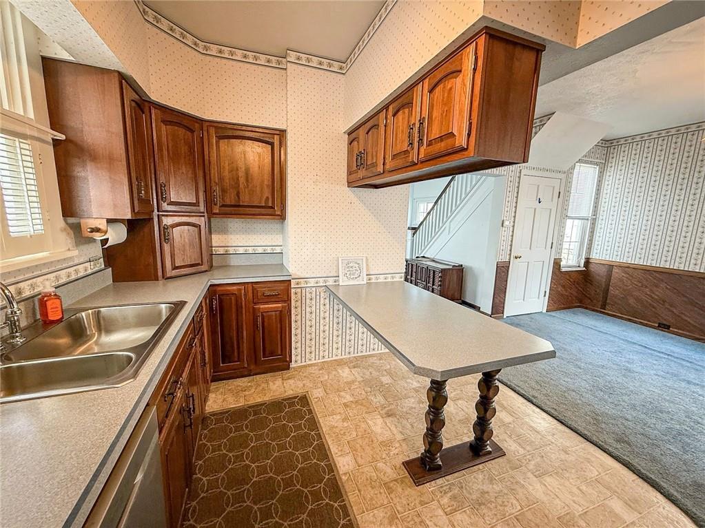 117 Lyon Avenue Butler, PA 16001 - Photo 17 of 43 a kitchen with stainless steel appliances granite countertop a sink a stove and a wooden floors