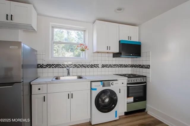 a utility room with sink dryer and washer