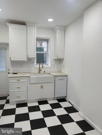 a kitchen with a checkered floor and white cabinets