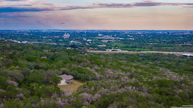 an aerial view of residential houses with outdoor space and trees