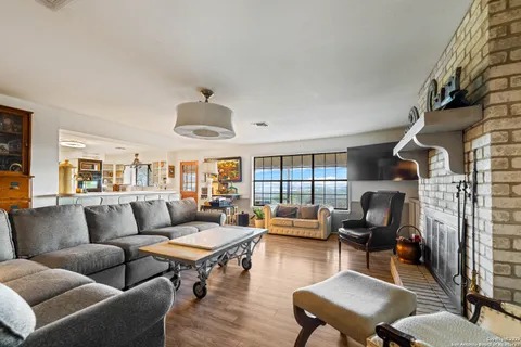 a living room with furniture fireplace and a large window